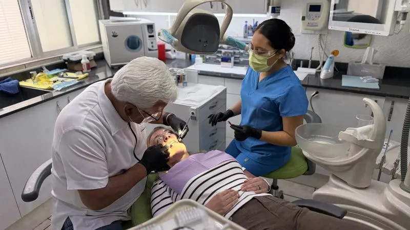 El Dr. Guerrero y su asistente atendiendo a una paciente en el consultorio
