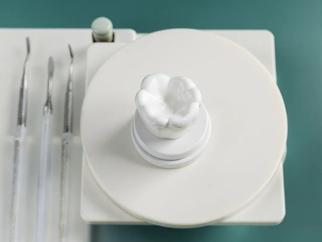 Corona dental terminada sobre el banco del laboratorio dental